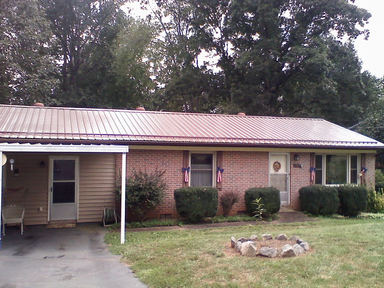 Bronze metal roof and carport on a brick ranch home — Roof Repair work by our crew in Cedar Valley